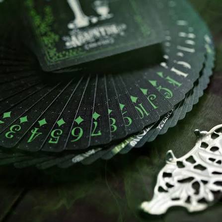 Black and green playing cards on a dark table